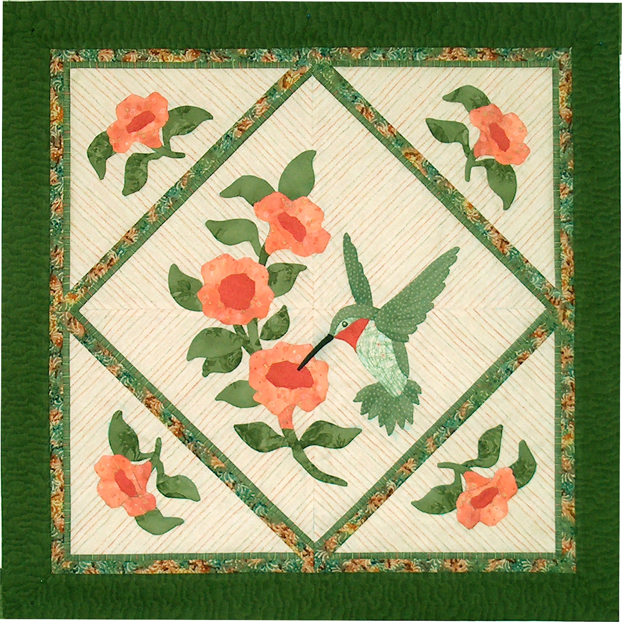 Beautiful quilt features a diamond in the middle with a hummingbird enjoying nectar from a flower. The other points of the diamond include other flowers with the diamond bordered with green like the rest of the square quilt. The quilt features mostly green and peach fabric.