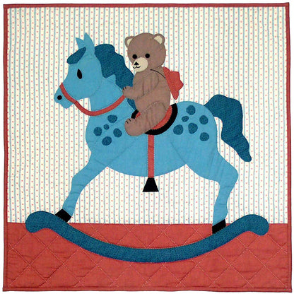 Adorable wall quilt features a blue rocking horse with a cute brown teddy bear (with a cowboy hanging behind his back) riding it.