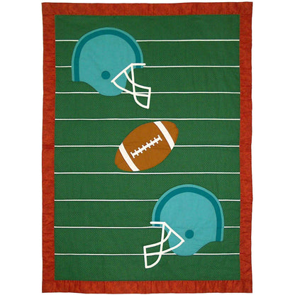 Crib-sized quilt with football field with lines on green with a football in the middle and two helmets.