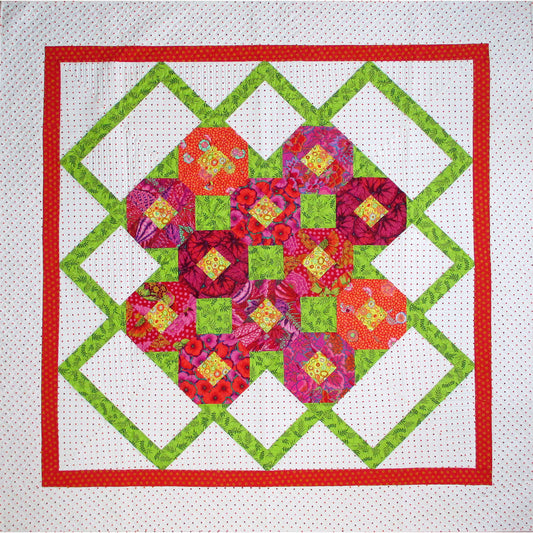 Sweet, floral quilt features a green zig-zag pattern on the outside of a grouping of colorful snowblock flowers.