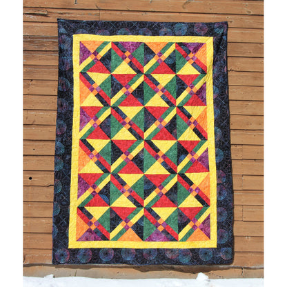 Colorful quilt with geometric pattern on a wooden floor