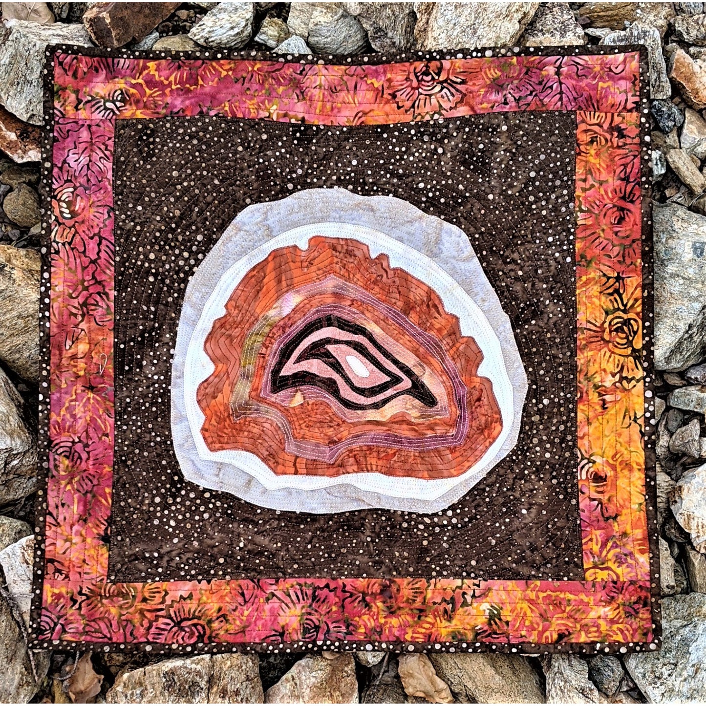 Decorative quilt with agate stone design on a stone background