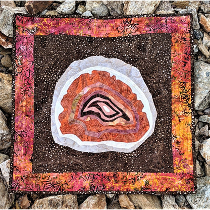 Decorative quilt with agate stone design on a stone background