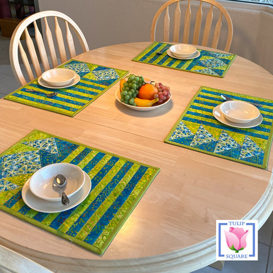 Table set with four placemats that have strips and diamonds on them.