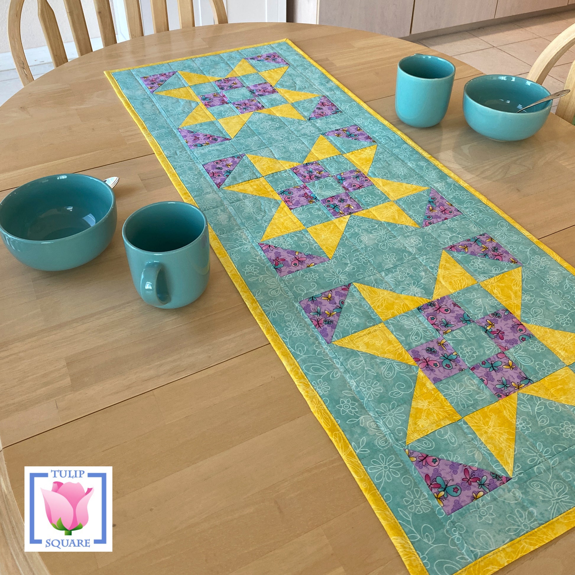Adorable 2 color and background color table runner. Looks like 3 Xs in the middle or stars, depending on how you look at it.  9-patch in the middle with one color and background. Then the points to the star in the other color. 