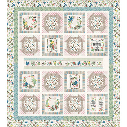 Sunshine and Song quilt features a bird study panel cut up with matching fabric of churn dash blocks and blocks with panel blocks. The theme of the fabric is birds with a long printed panel piece in the middle.