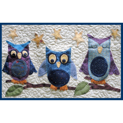 Quilt with three colorful owl designs on a white background
